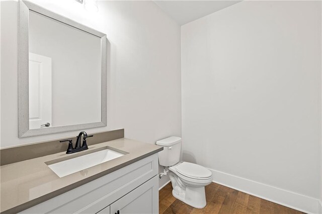 171 Blue Rider Trl, Hoschton, GA 30548 - half bath with baseboards, vanity, toilet, and wood finished floors
