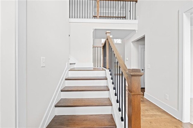 171 Blue Rider Trl, Hoschton, GA 30548 - stairway with baseboards, a towering ceiling, and wood finished floors