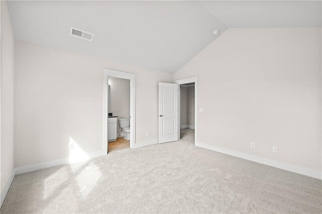 171 Blue Rider Trl, Hoschton, GA 30548 - unfurnished bedroom featuring visible vents, vaulted ceiling, baseboards, a spacious closet, and light carpet