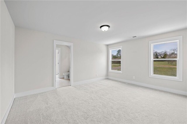 171 Blue Rider Trl, Hoschton, GA 30548 - unfurnished bedroom with connected bathroom, baseboards, and light carpet