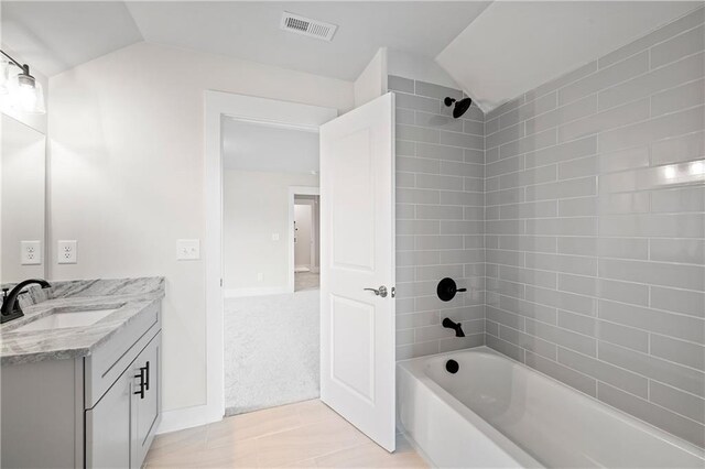 171 Blue Rider Trl, Hoschton, GA 30548 - bathroom featuring visible vents, bathtub / shower combination, vaulted ceiling, and vanity