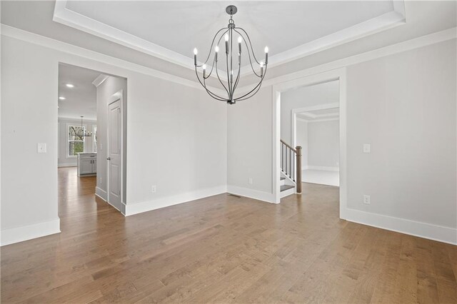 171 Blue Rider Trl, Hoschton, GA 30548 - empty room featuring an inviting chandelier, wood finished floors, and a raised ceiling