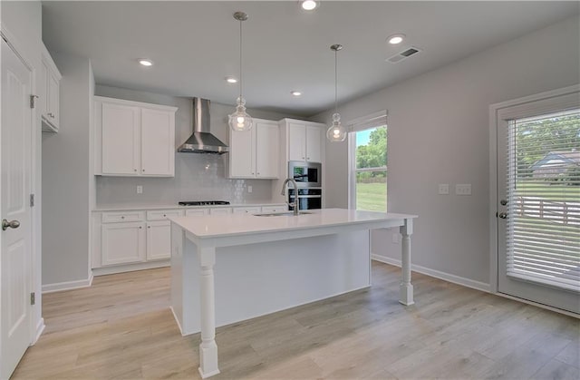 237 Chiswick Loop, Stockbridge, GA 30281 - kitchen featuring a sink, visible vents, white cabinetry, wall chimney range hood, and light countertops