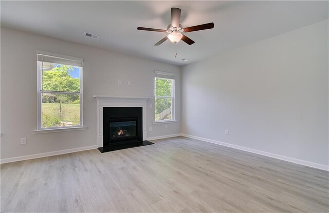 237 Chiswick Loop, Stockbridge, GA 30281 - unfurnished living room with light wood finished floors, baseboards, visible vents, and a healthy amount of sunlight