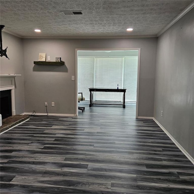 unfurnished living room with a textured ceiling, ornamental molding, and dark wood-type flooring