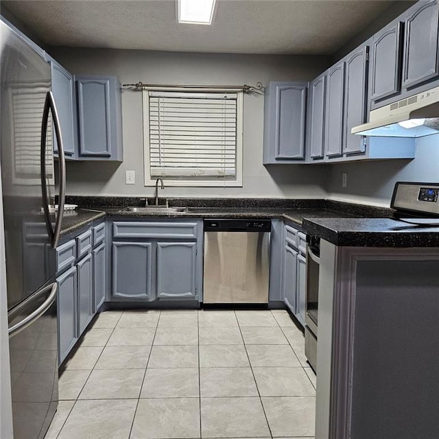 kitchen featuring gray cabinetry, sink, light tile patterned floors, and appliances with stainless steel finishes