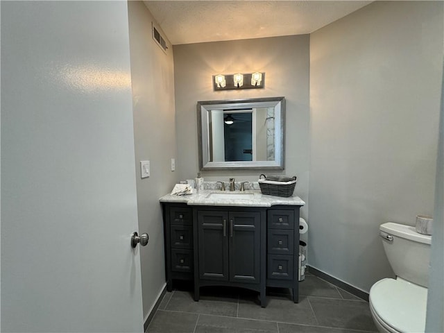 bathroom with tile patterned flooring, vanity, and toilet