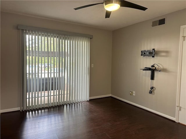 spare room featuring ceiling fan, dark hardwood / wood-style flooring, and a healthy amount of sunlight