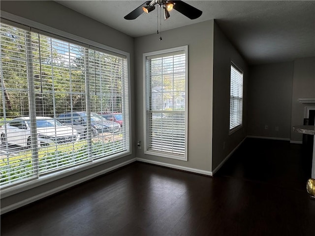 spare room with ceiling fan, dark hardwood / wood-style flooring, and a textured ceiling