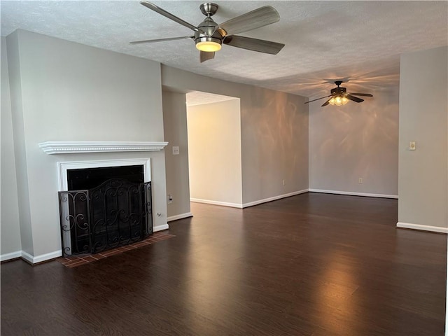 unfurnished living room with ceiling fan, a textured ceiling, and dark wood-type flooring