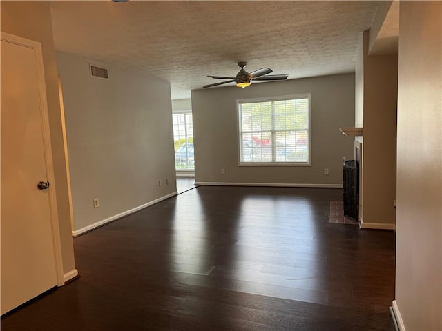 unfurnished living room with ceiling fan, a textured ceiling, and dark wood-type flooring