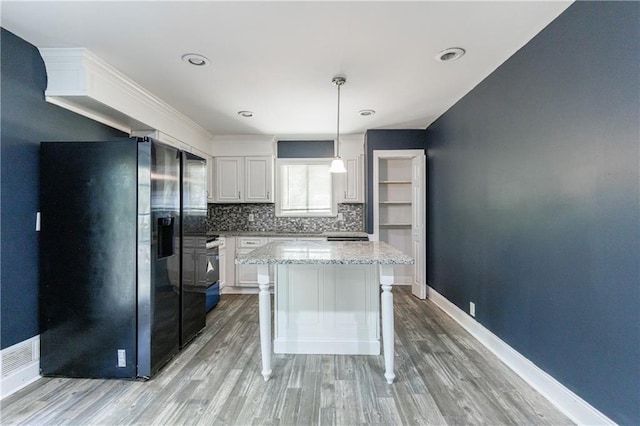 5287 Chantilly Ter, Atlanta, GA 30349 - kitchen featuring tasteful backsplash, a kitchen island, white cabinets, black refrigerator with ice dispenser, and light wood-style floors
