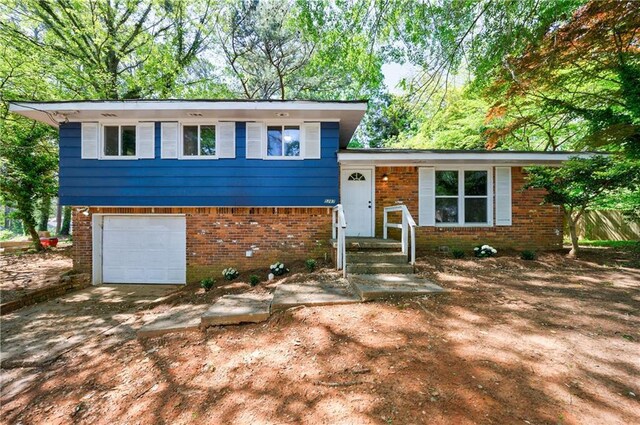 5287 Chantilly Ter, Atlanta, GA 30349 - split level home with concrete driveway, brick siding, and an attached garage