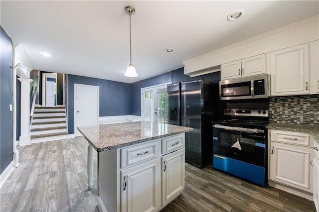 5287 Chantilly Ter, Atlanta, GA 30349 - kitchen with tasteful backsplash, white cabinetry, a kitchen island, appliances with stainless steel finishes, and wood finished floors