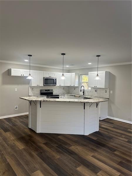 kitchen featuring hanging light fixtures, white cabinets, appliances with stainless steel finishes, and a center island