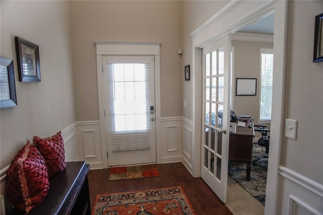 entryway featuring a wainscoted wall, a decorative wall, dark wood finished floors, and french doors