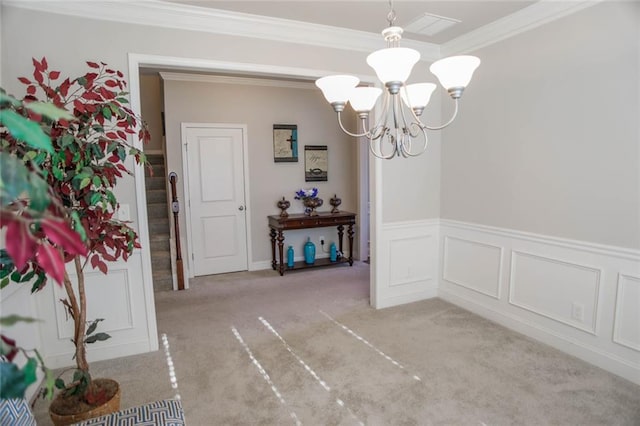 unfurnished dining area with light carpet, stairway, crown molding, a chandelier, and a decorative wall