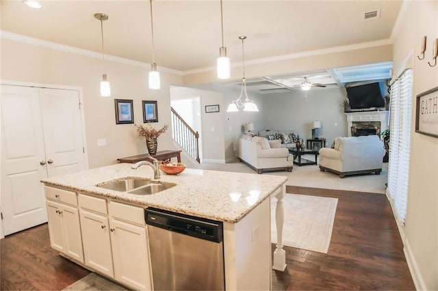 kitchen featuring a stone fireplace, a sink, dark wood-style floors, dishwasher, and crown molding