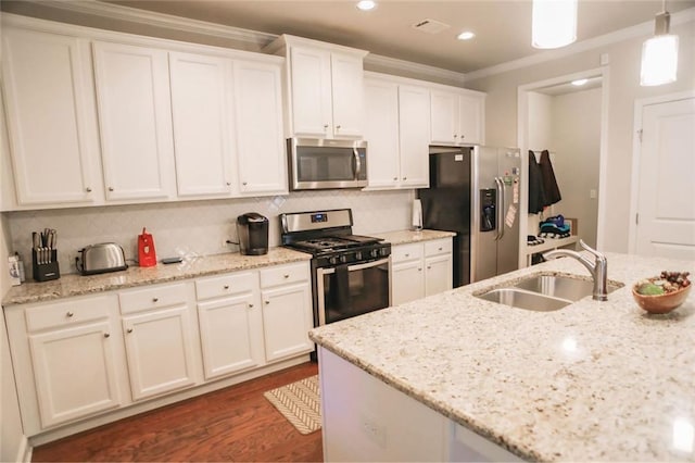 kitchen with crown molding, backsplash, appliances with stainless steel finishes, white cabinets, and a sink