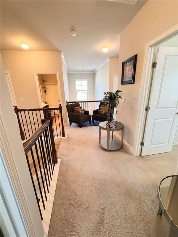 corridor featuring light carpet, baseboards, ornamental molding, and an upstairs landing