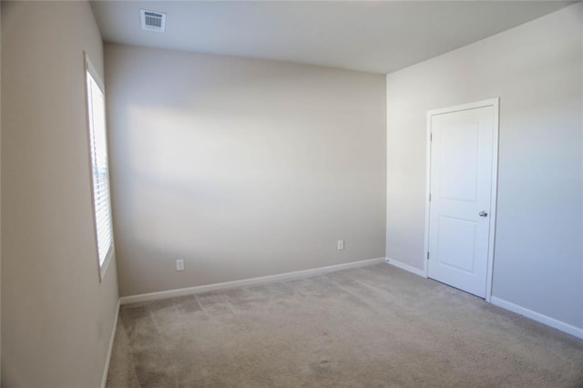 carpeted empty room featuring visible vents and baseboards