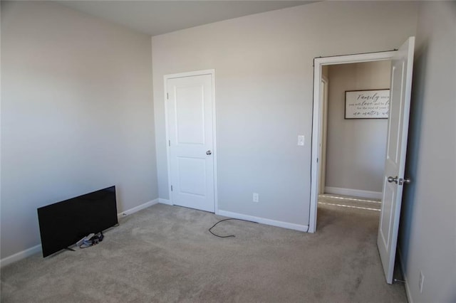 unfurnished bedroom featuring carpet flooring and baseboards