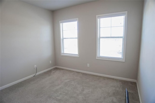 carpeted spare room featuring baseboards