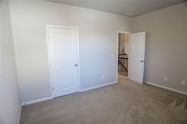 unfurnished bedroom featuring carpet, visible vents, and baseboards