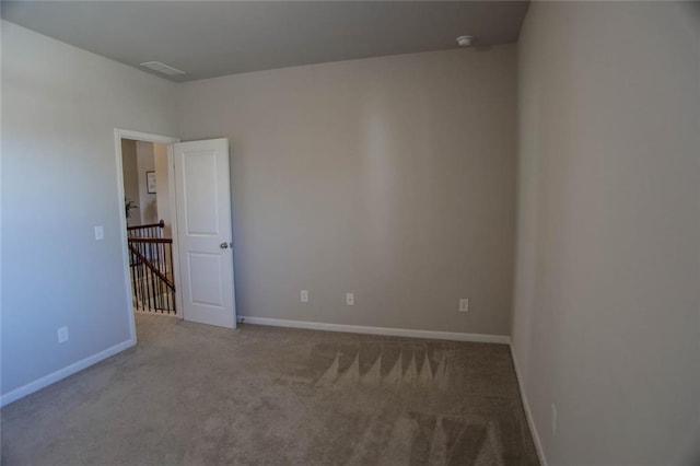 carpeted empty room featuring baseboards