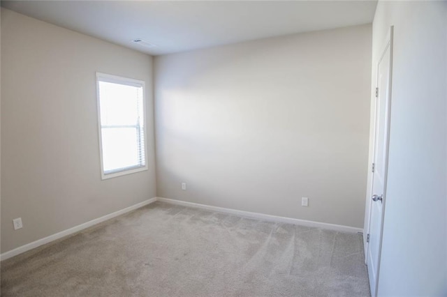 spare room with light colored carpet and baseboards