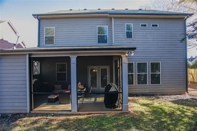 back of house with a yard, a patio, and a sunroom