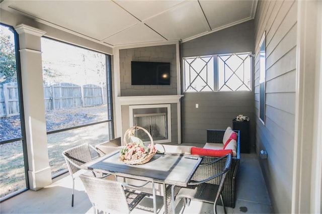 sunroom featuring a healthy amount of sunlight and a fireplace