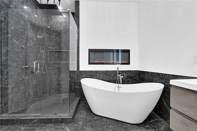 2207 Concordia Way SE Unit 12, Mableton, GA 30126 - bathroom featuring tile walls, marble tiled floors, a freestanding tub, a marble finish shower, and a glass covered fireplace