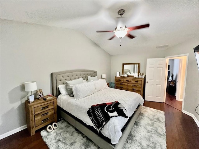 bedroom featuring baseboards, lofted ceiling, wood finished floors, and a ceiling fan