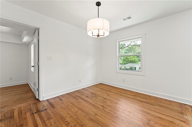 2146 Trailwood Rd, Decatur, GA 30032 - spare room featuring wood finished floors, visible vents, baseboards, and a notable chandelier