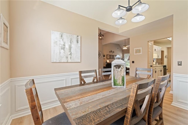 15 Fairwoods Ct, Covington, GA 30016 - dining space featuring light wood-type flooring, a decorative wall, a wainscoted wall, a chandelier, and a ceiling fan