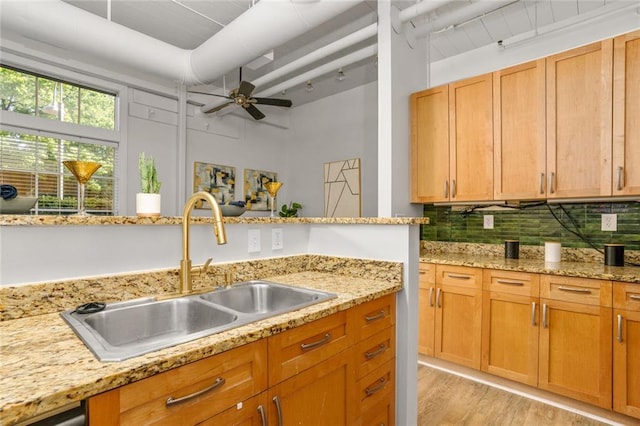 572 Edgewood Ave SE Unit # 106, Atlanta, GA 30312 - kitchen with a ceiling fan, a sink, light wood finished floors, backsplash, and light stone countertops