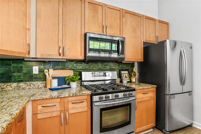 572 Edgewood Ave SE Unit # 106, Atlanta, GA 30312 - kitchen with light stone countertops, stainless steel appliances, and decorative backsplash