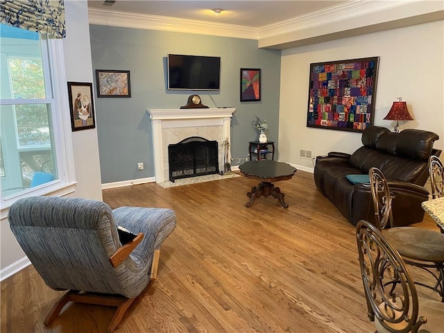 living room with hardwood / wood-style flooring, a premium fireplace, and crown molding