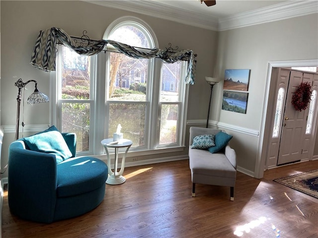 living area with crown molding, dark wood-type flooring, and a healthy amount of sunlight