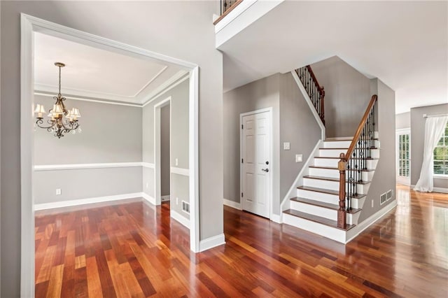 interior space featuring crown molding, dark hardwood / wood-style floors, and a chandelier