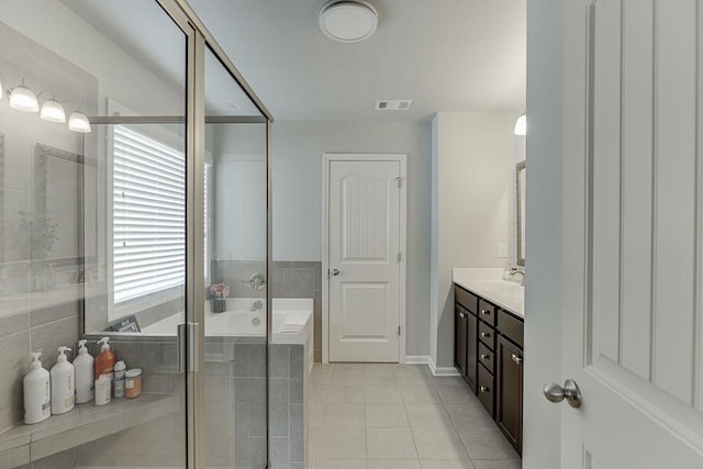 bathroom with a shower with shower door, tile patterned floors, and vanity