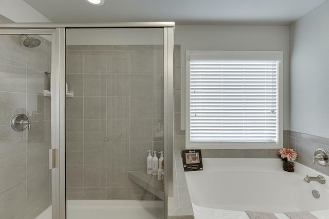 bathroom featuring a wealth of natural light and independent shower and bath