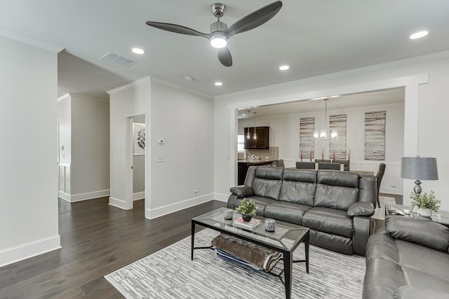 living room with ceiling fan with notable chandelier, dark hardwood / wood-style floors, and ornamental molding