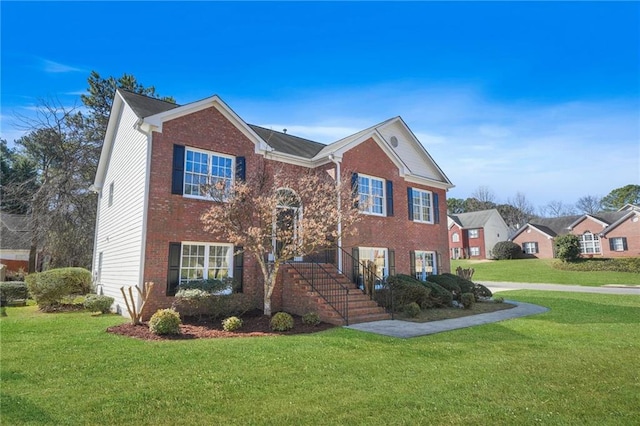 traditional home with a front yard and brick siding