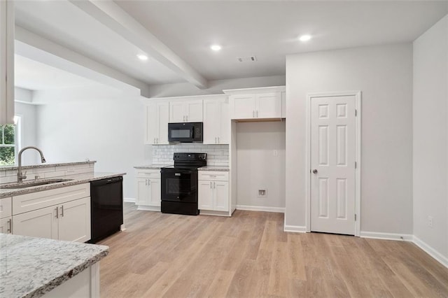 kitchen with black appliances, a sink, white cabinets, backsplash, and light wood finished floors