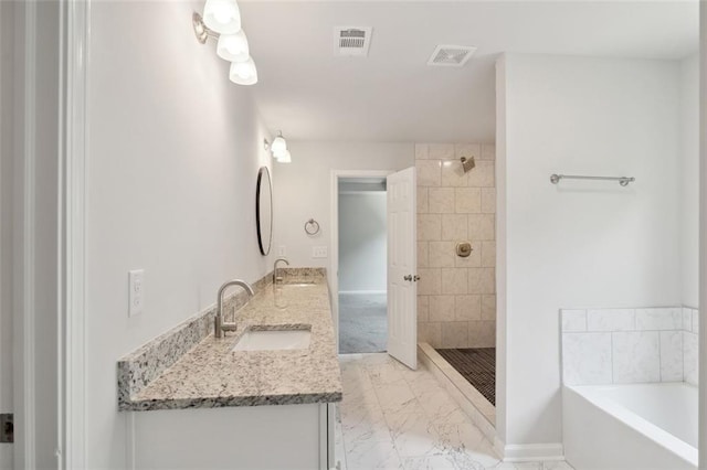 bathroom featuring marble finish floors, a bath, tiled shower, and double vanity
