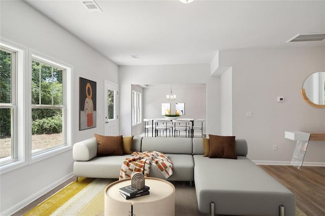 living room with baseboards, a chandelier, and wood finished floors