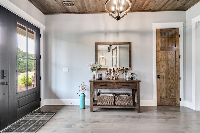 foyer with hardwood / wood-style flooring, a notable chandelier, and wood ceiling