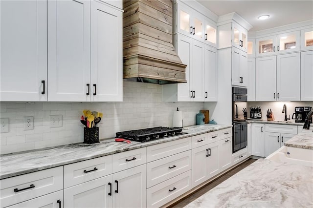 kitchen featuring white cabinetry, gas cooktop, light stone counters, and backsplash